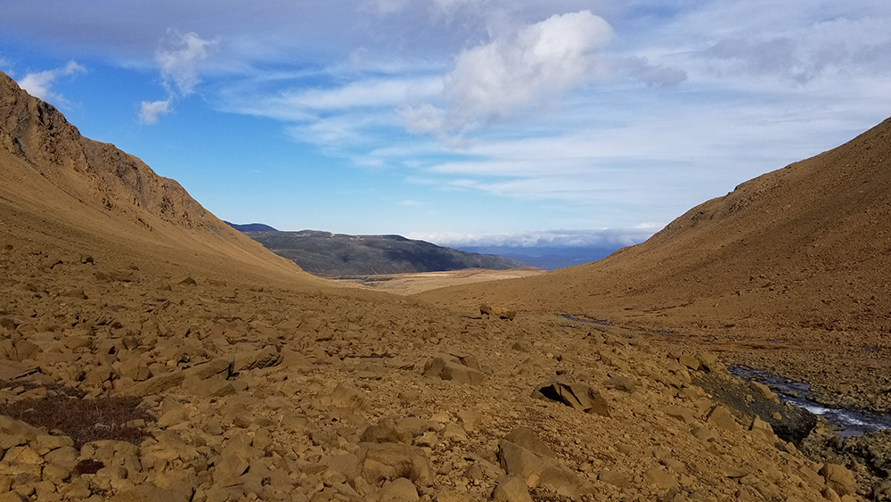 Landscape of Newfoundland with red rocks in a valley between Mountains similar to the surface of Mars.