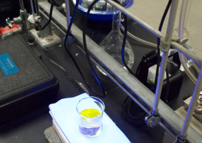 A glass with liquid sits on a scale in a lab.