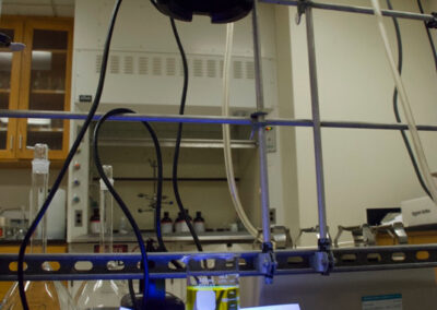 A glass beaker of liquid sits on a device on a counter in a lab.