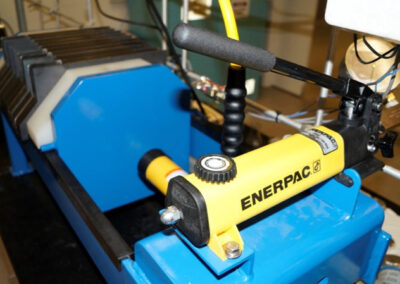 A machine in a lab with the word Enerpac and a lever.